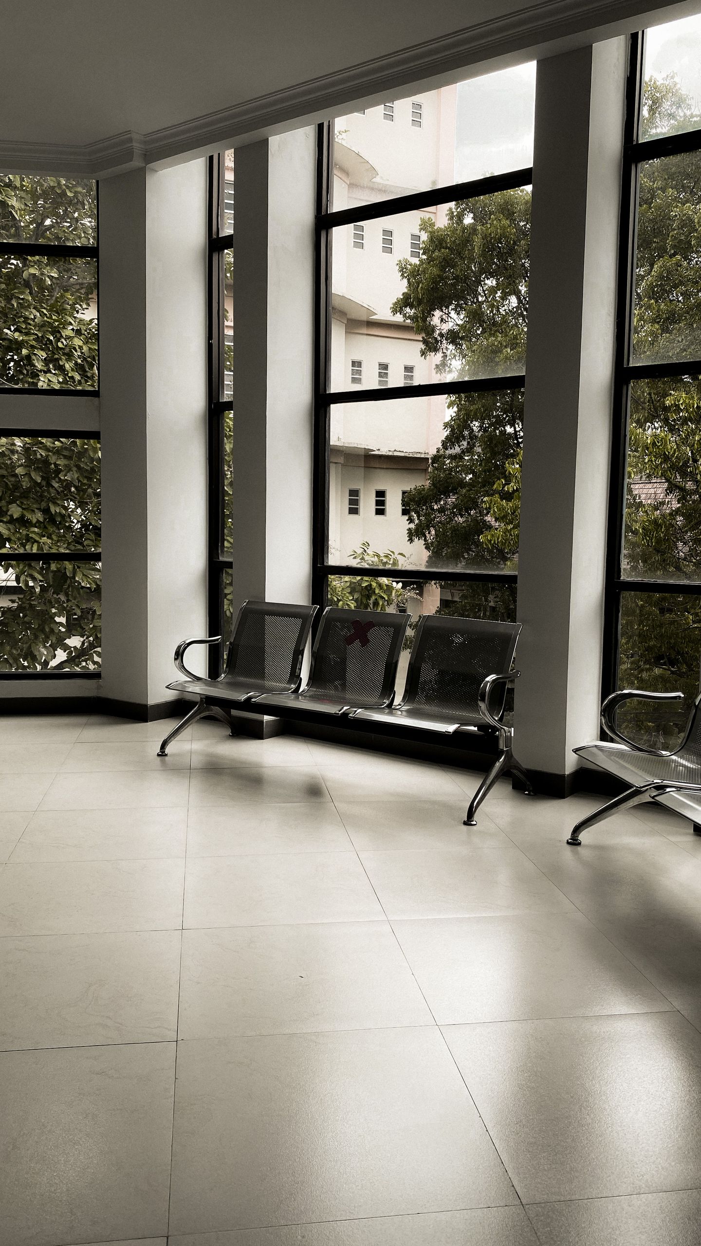 Spacious indoor room with metal seats and large windows in Malang, Indonesia.